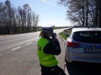 Policjantka dokonująca pomiaru prędkości policyjnym miernikiem prędkości