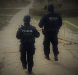 Dwóch policjantów z patrolu idzie ścieżką.