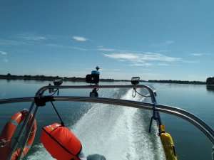 łódka policyjna płynąca po jeziorze