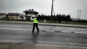 Policjant wchodzi na ulicę z lizakiem w ręce, zatrzymuje pojazd do kontroli