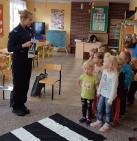 Policjantka pokazująca znak drogowy, dzieci
