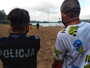 Policjantka i uczestnik biegu, w tle jezioro