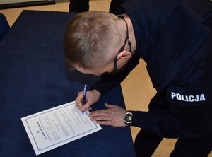 policjant podpisujący akt ślubowania