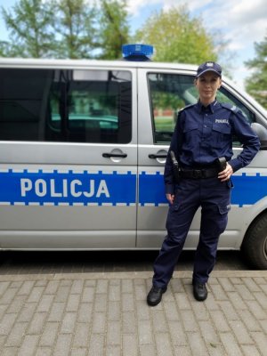 Policjantka przy radiowozie.